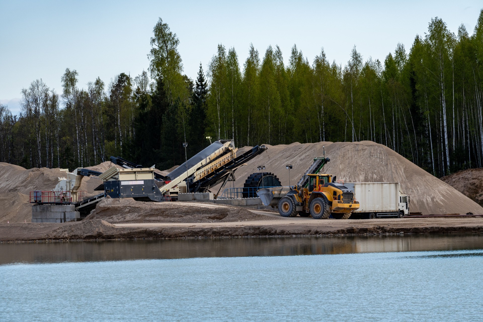 Sand Quarry Operations by the Water. Industrial Sand Excavation in Nature Setting